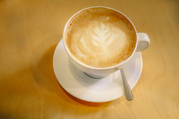 Top view of white cup of hot cappuccino coffee on marble table.