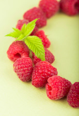 wreath made of raspberries on white background
