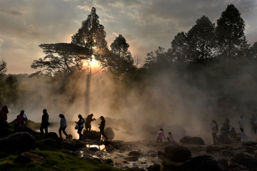 People in a hot spring with fog and light ray in a morning