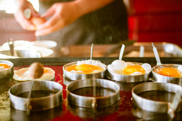 Blurred woman hand cooked fried egg.Fried egg on frying pan. 