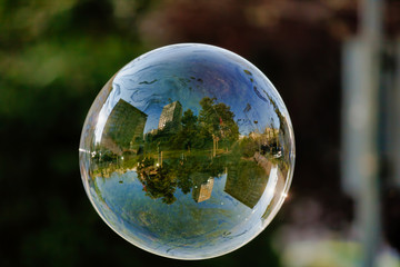 Lonely Colorful Soap Bubble with Reflection of the City and Sky Inside It