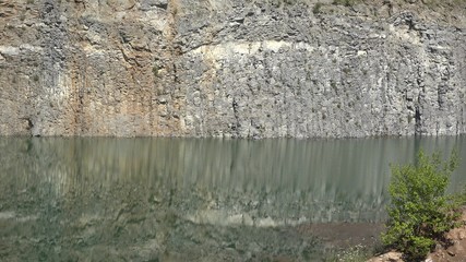 Basalt wall reflected into volcanic lake