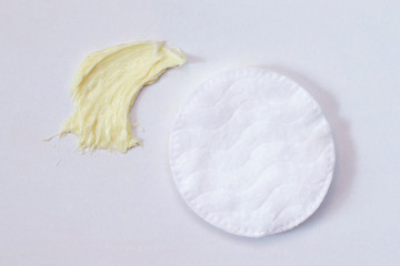 Refreshing skin care cream and cotton pads on a light background