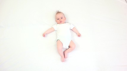 Cute baby lying on bed and move fast arms and legs, time lapse, hyperactivity , white background, big challenge to take care of this king of child