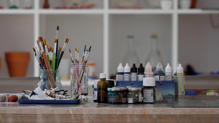 Hand chosing brushes and colors to paint