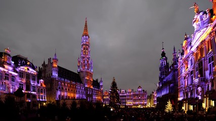 Fototapeta na wymiar Winter Wonders sound and light festival in Brussels Grand Place, a colorful show that gathers tourists to admire Christmas tree by night in the city center