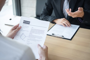Employer or recruiter holding reading a resume during about colloquy his profile of candidate, employer in suit is conducting a job interview, manager resource employment and recruitment concept