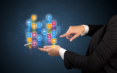 Female elegant hand holding tablet with colourful application icons