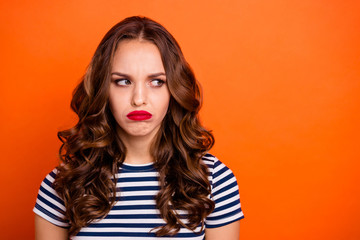 Close up photo beautiful she her lady red lipstick pomade look side empty space not satisfied weather bad mood wear casual striped white blue t-shirt clothes isolated orange bright background