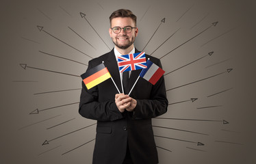 Smiling young man standing with flag and multidirectional arrows around

