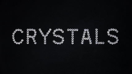 Word Crystals made of shiny white swarovski crystals placed on black leather