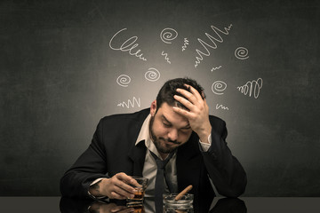 Young drunk man at his office with doodles around
