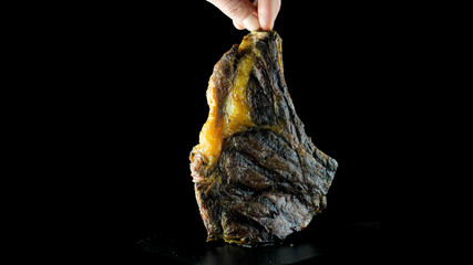 T-bone steak full-length grilled on an isolated black background