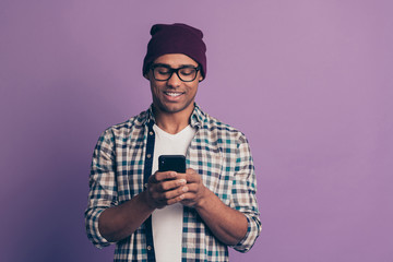 Fototapeta na wymiar Photo portrait of cheerful cool swag trend trendy guy leaving his feedback on social media network using smart phone isolated violet background