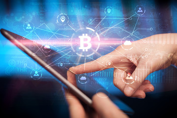 Hand using tablet with cryptocurrency bitcoin link network and online concept
