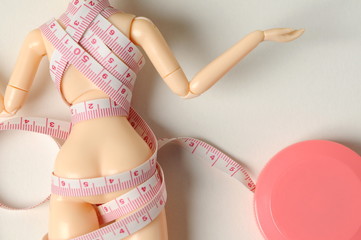 ドールにテープメジャーを巻いている