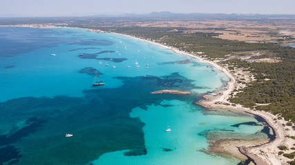 Fototapeta na wymiar Amazing drone aerial landscape of the charming area of Es Trencs and the boats with a turquoise sea. It has earned the reputation of Caribbean beach of Mallorca. Spain