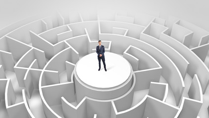 Businessman standing on the top a maze and looking through
