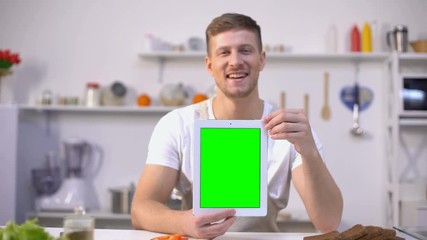 Handsome man holding tablet with green screen, cooking courses application