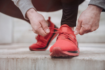 Close up of a man tying up his shoelaces before the run with copy space