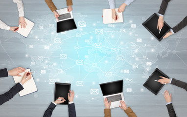 Group of people with devices in hands working in team on tablets, laptops with application concept
