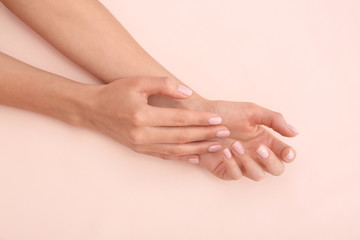 Closeup view of woman with beautiful hands on color background. Spa treatment