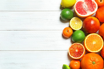 Flat lay composition with different citrus fruits and space for text on white wooden background