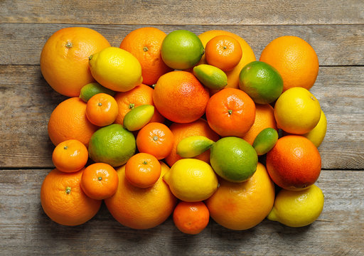 Flat lay composition with different citrus fruits on wooden background © New Africa