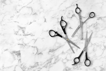 Flat lay composition with scissors and space for text on marble background. Hairdresser tools