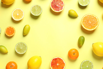 Frame made of different citrus fruits on color background, flat lay. Space for text