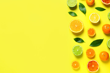 Different citrus fruits and leaves on color background, flat lay. Space for text