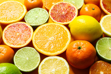 Different citrus fruits on color background, closeup