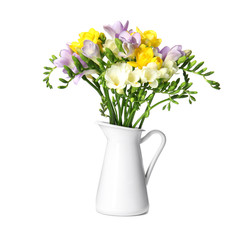 Bouquet of fresh freesia flowers in jug isolated on white