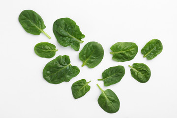 Obraz premium Fresh leaves of spinach isolated on white, top view