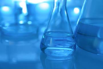 Laboratory glassware with liquid on table, closeup. Space for text