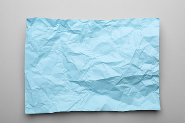 Color sheet of crumpled paper on grey background, top view