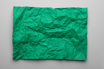 Color sheet of crumpled paper on grey background, top view