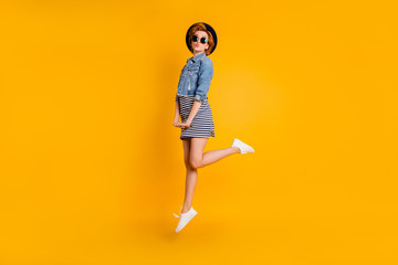 Fototapeta na wymiar Full length side profile body size photo foxy she her chic lady jumping high weekend mood send air kisses wear specs vintage hat casual striped dress jeans denim isolated yellow bright background