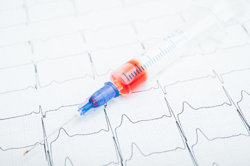 ECG results on paper and red injections to restore heart pulse