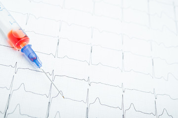 ECG results on paper and red injections to restore heart pulse