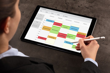 Business woman schedule her weekly program on tablet
