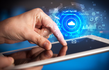 Hand holding tablet with cloud storage technology concept
