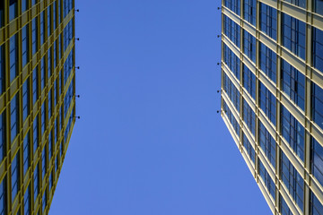 Vertical view of a tall concrete modern high building with geometric details against a blue sky