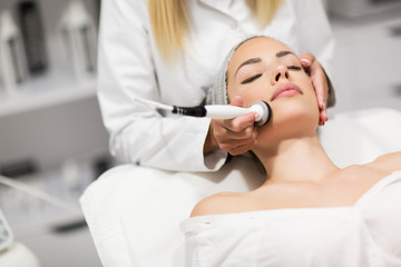 Obraz na płótnie Canvas Beautiful woman in professional beauty salon during photo rejuvenation procedure