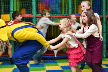 A group of children at a party play, run for the animator and hold hands