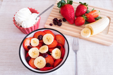 Healthy and sweet break or breakfast with a cup of strawberry, redberry and banana. Some cream for the greedy.