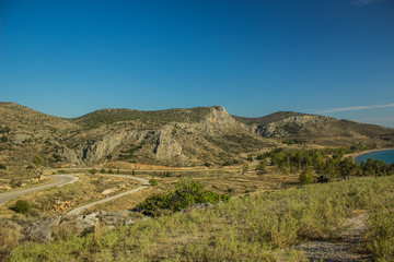 Morocco north African dry hill land scenery landscape from above with yellow grass and small mountain background near sea