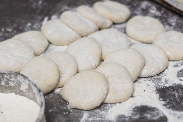 Fototapeta na wymiar Raw dough on the backery table. Preparing bread dough for backing bread. Food preparing concept