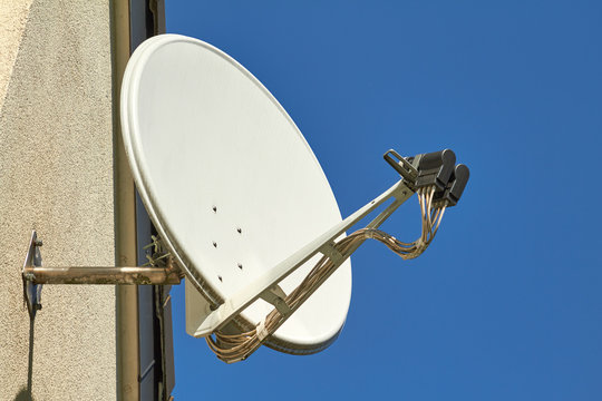 Eine Satellitensch&uuml;ssel an einer Hauswand.