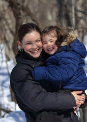 mother and child having fun outdoor during winter